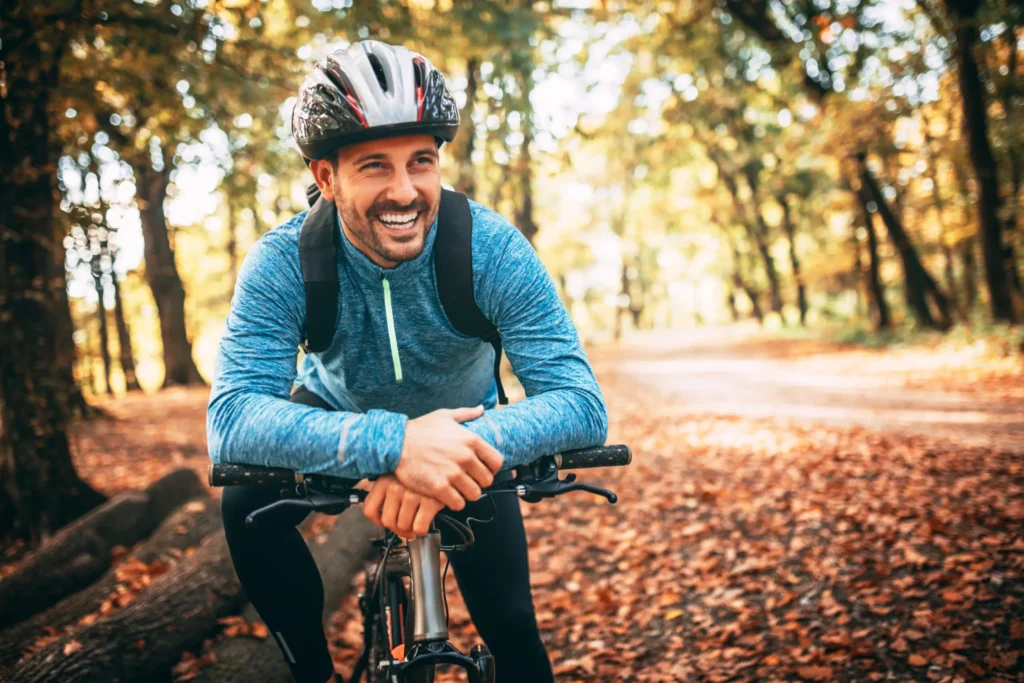 A man riding his bike in the woods on a trail.