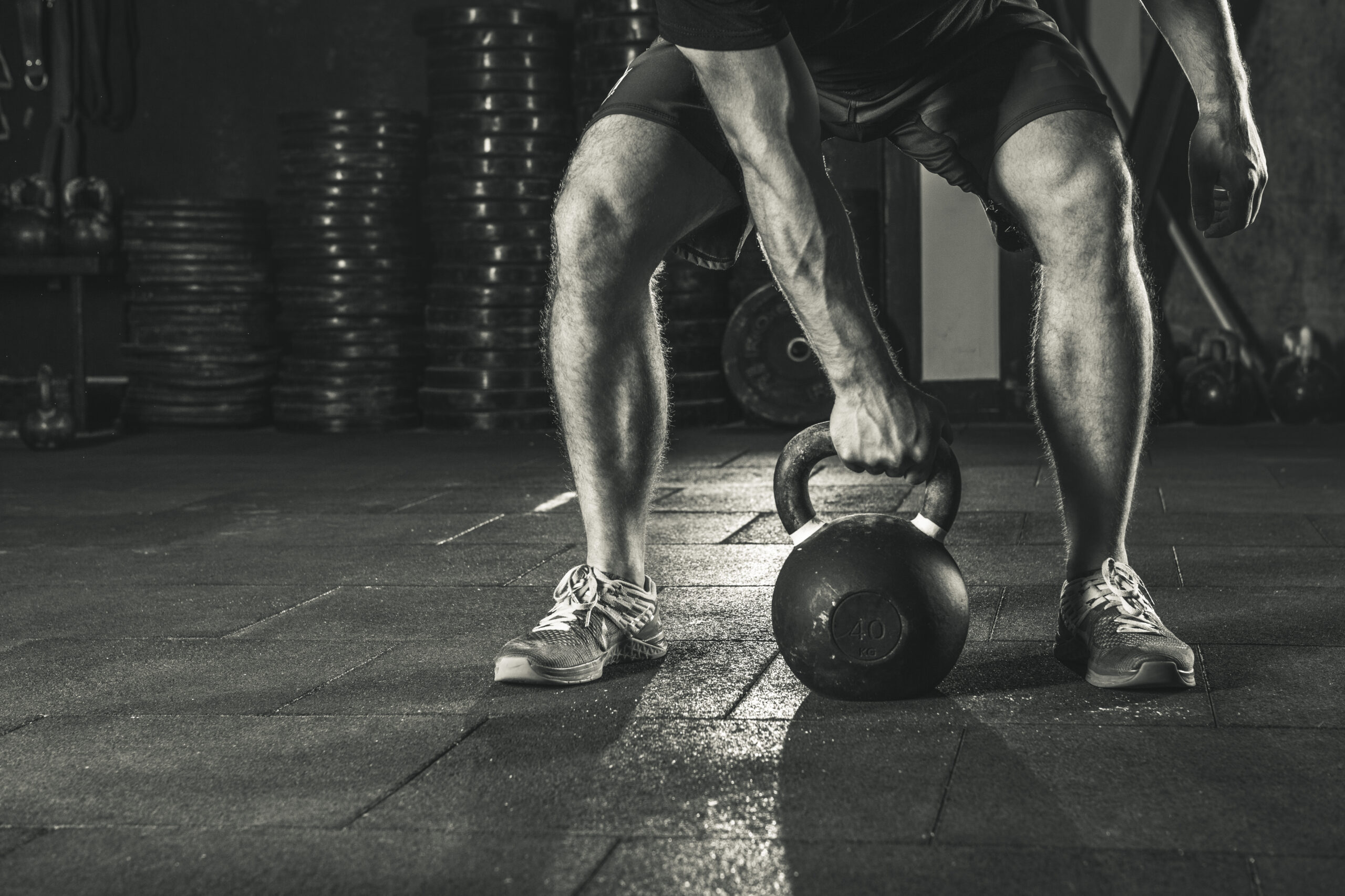 A man is holding onto a kettlebell in the gym.