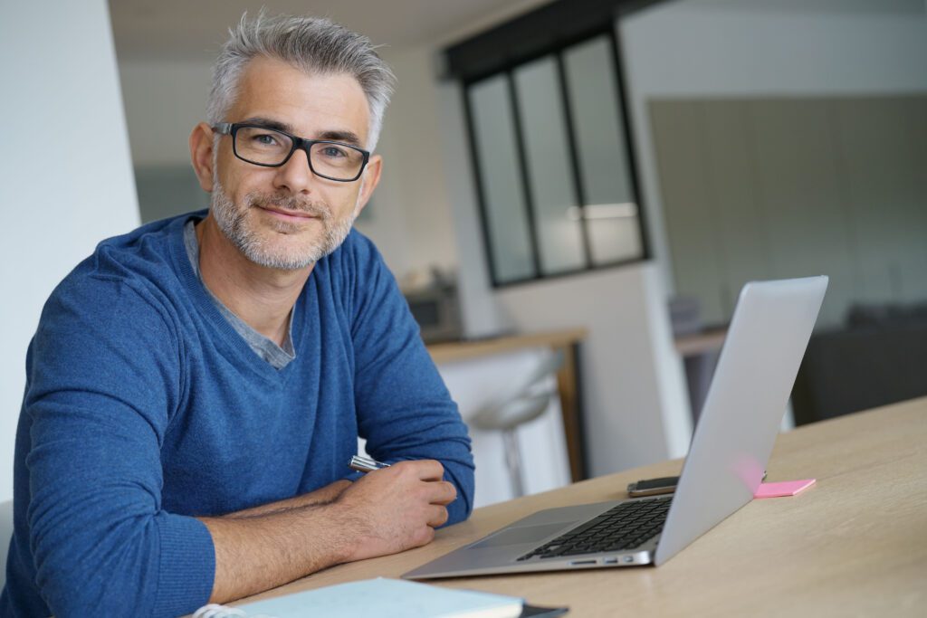 A man sitting at a table with his laptop.